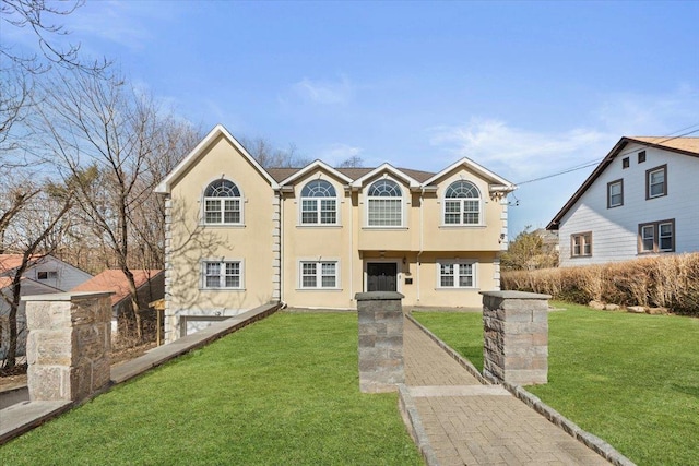 view of front of home with stucco siding and a front yard