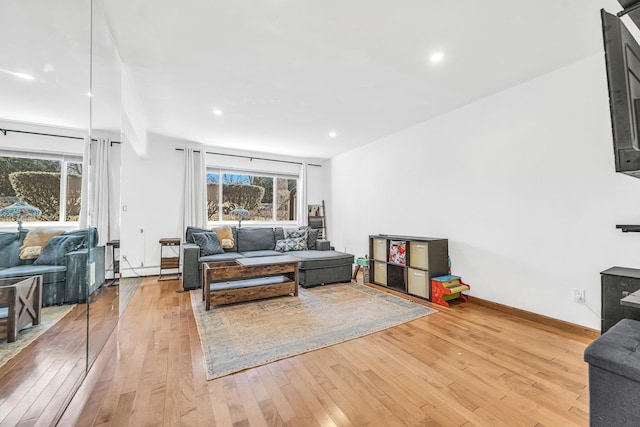 living area with recessed lighting, baseboards, and light wood finished floors