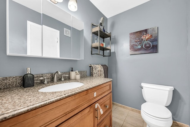 bathroom featuring toilet, vanity, baseboards, and tile patterned floors