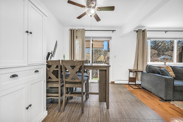 office with a ceiling fan, plenty of natural light, baseboard heating, and wood finished floors