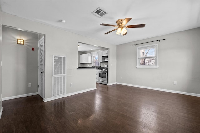 unfurnished living room with dark wood finished floors, visible vents, baseboards, and ceiling fan