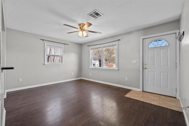 foyer entrance featuring visible vents, baseboards, a ceiling fan, and wood finished floors