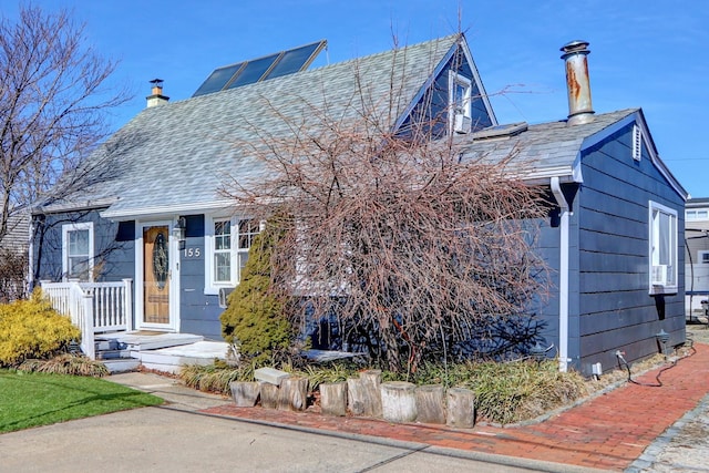 view of front of home featuring a chimney and roof with shingles