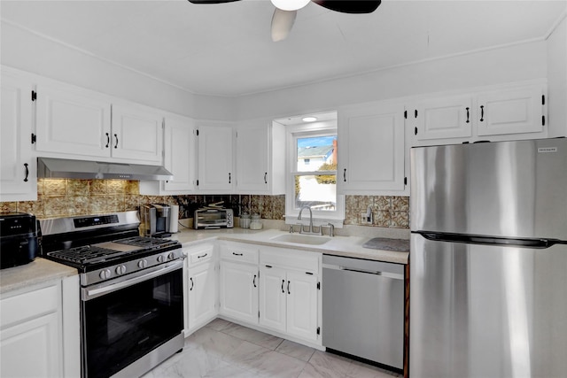 kitchen with extractor fan, stainless steel appliances, a sink, marble finish floor, and decorative backsplash