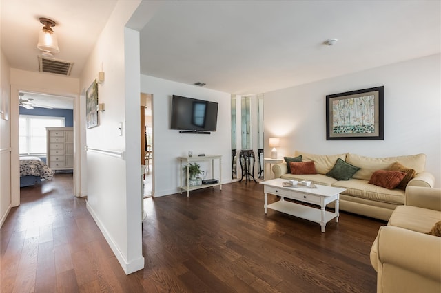 living room featuring wood finished floors, visible vents, and baseboards