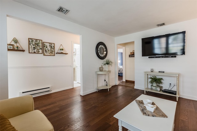 living area with a baseboard radiator, wood finished floors, visible vents, and baseboards