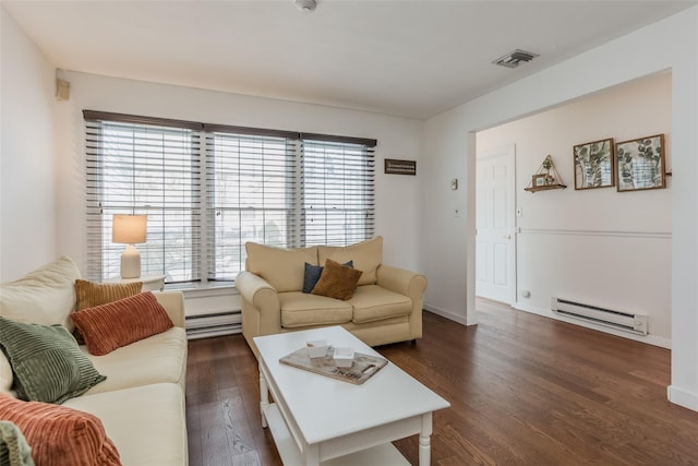 living area with a baseboard heating unit, dark wood-style flooring, visible vents, and baseboards