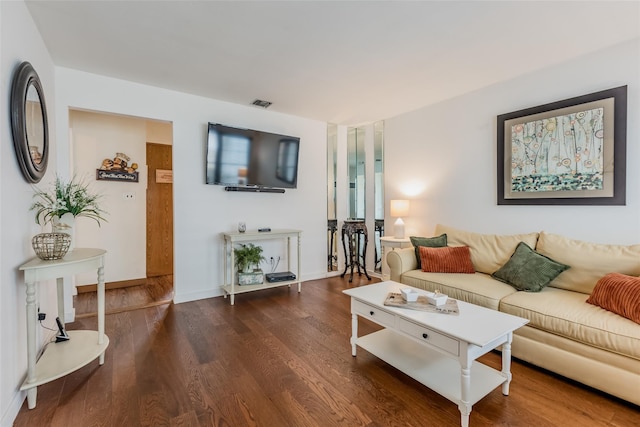 living area featuring wood finished floors, visible vents, and baseboards