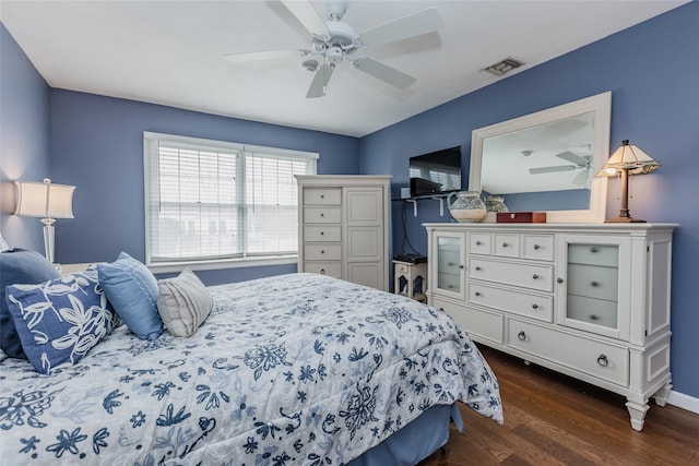 bedroom with dark wood-style floors, ceiling fan, visible vents, and baseboards