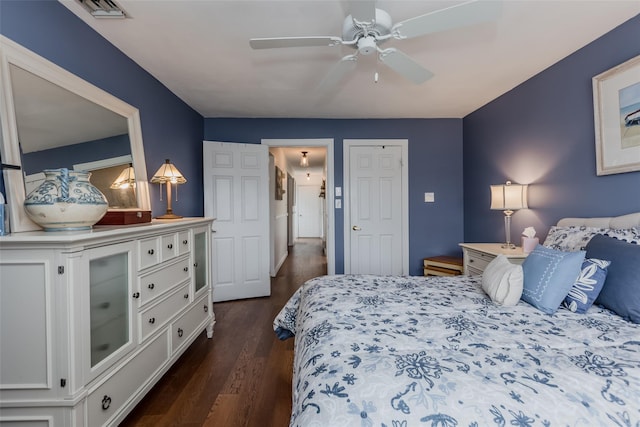 bedroom featuring dark wood finished floors, visible vents, and a ceiling fan