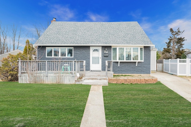 view of front facade featuring roof with shingles, fence, a chimney, and a front lawn