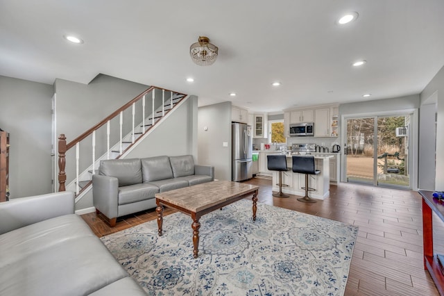 living area featuring stairs, dark wood finished floors, and recessed lighting