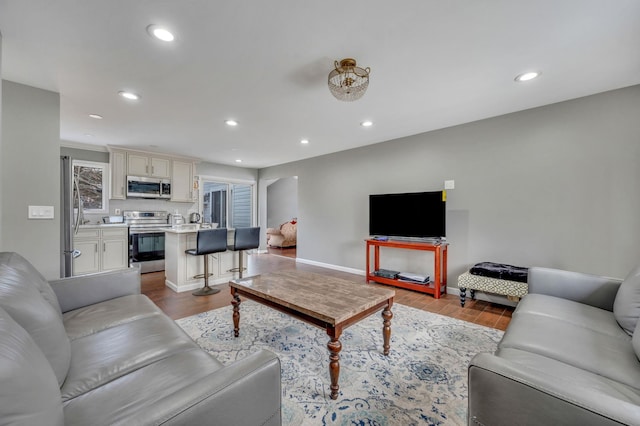 living room featuring baseboards, wood finished floors, and recessed lighting