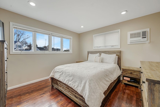 bedroom with recessed lighting, dark wood-style flooring, baseboards, and a wall mounted AC