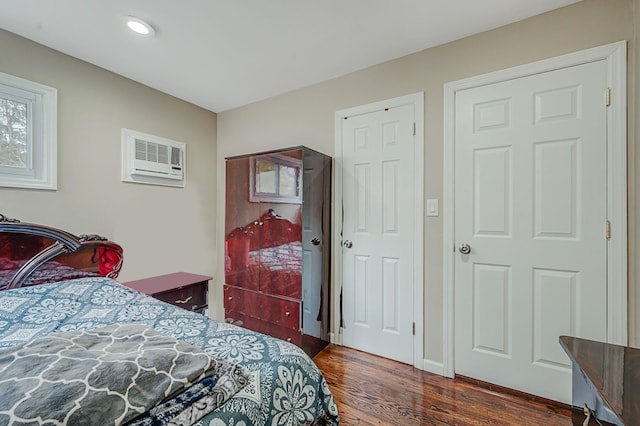 bedroom with dark wood-style floors, a wall mounted air conditioner, and recessed lighting