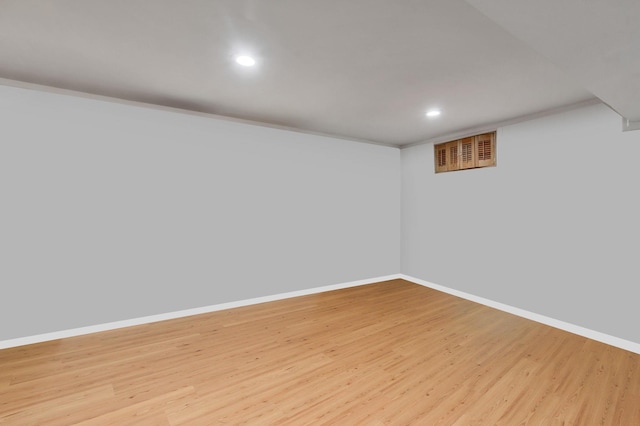 finished basement featuring recessed lighting, baseboards, visible vents, and light wood finished floors