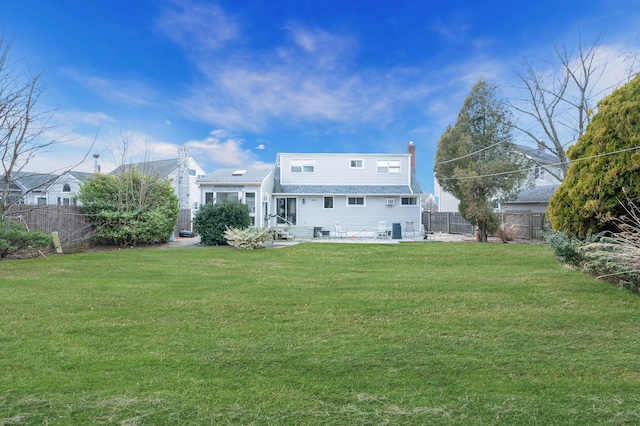 back of house featuring a fenced backyard, a lawn, and a patio