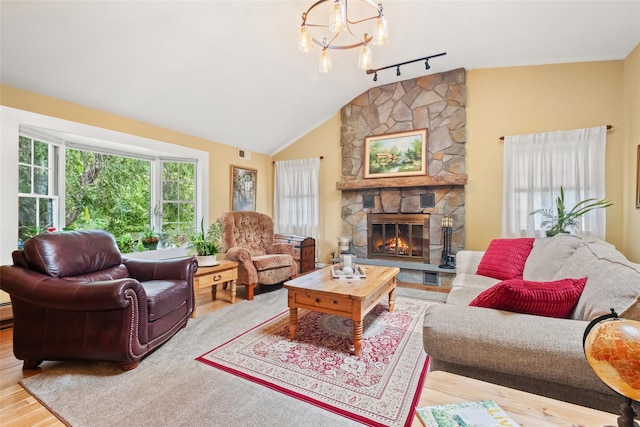 living area featuring lofted ceiling, a fireplace, wood finished floors, visible vents, and an inviting chandelier