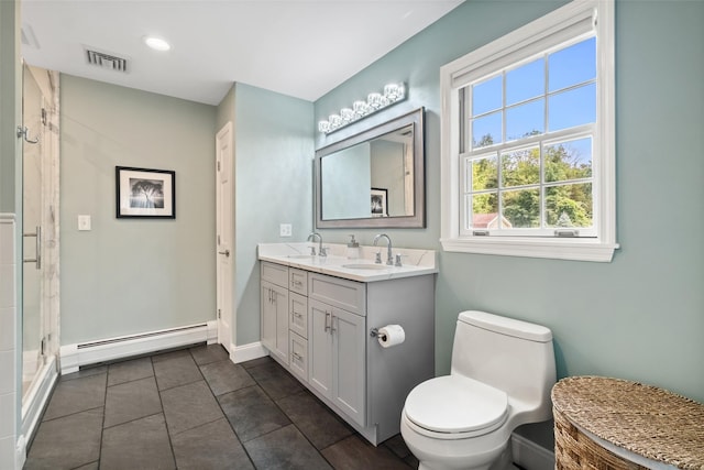 bathroom with toilet, visible vents, a sink, and baseboard heating