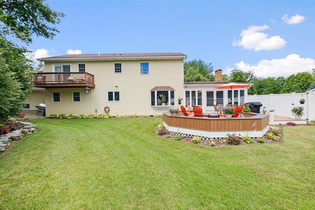 back of house featuring a yard, a chimney, fence, and a deck