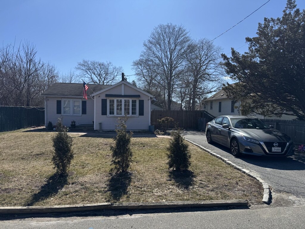 view of front facade featuring driveway and fence