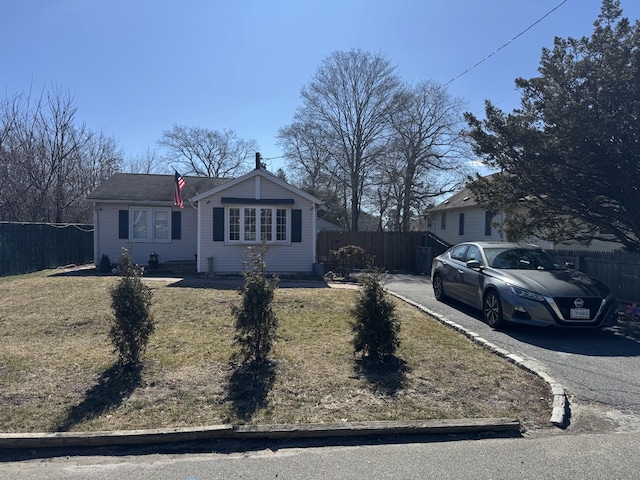 view of front facade featuring driveway and fence