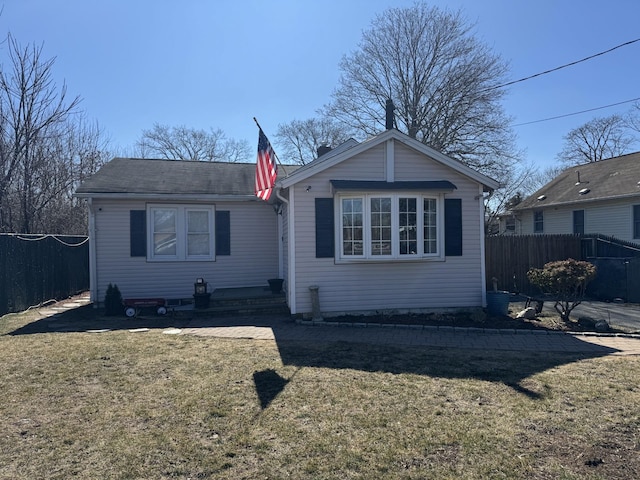 bungalow featuring a front yard and fence