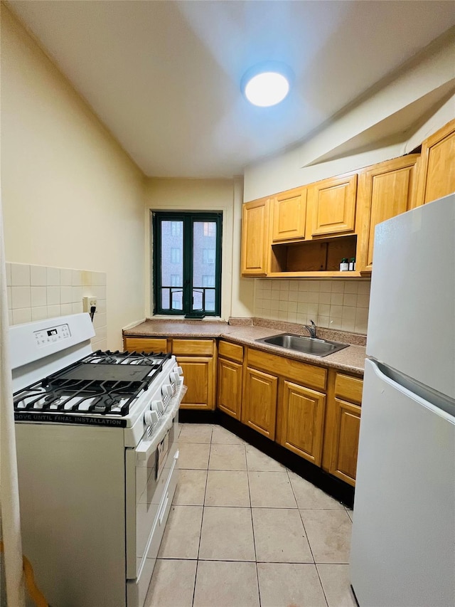 kitchen with white appliances, light tile patterned flooring, a sink, and decorative backsplash