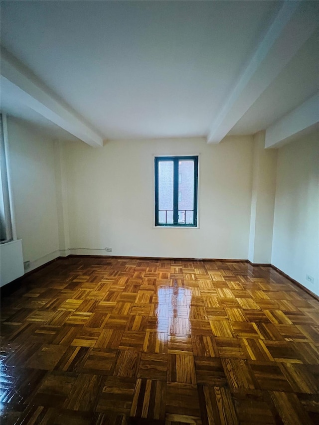 unfurnished room featuring radiator, beamed ceiling, and baseboards