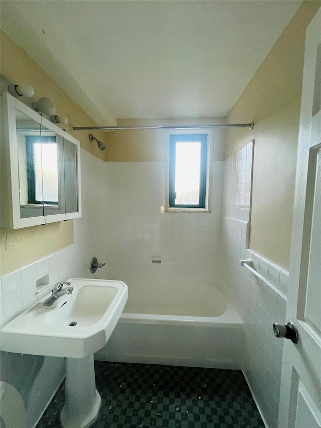 bathroom with washtub / shower combination and tile walls