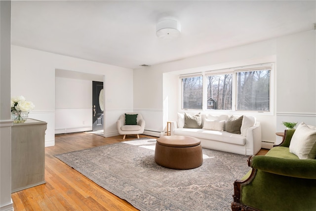 living room featuring light wood-style floors, a baseboard radiator, a baseboard heating unit, and visible vents