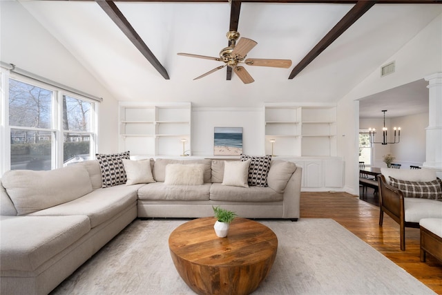 living room featuring visible vents, lofted ceiling with beams, light wood-type flooring, ornate columns, and ceiling fan with notable chandelier