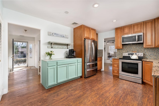 kitchen with stainless steel appliances, tasteful backsplash, dark wood finished floors, and visible vents