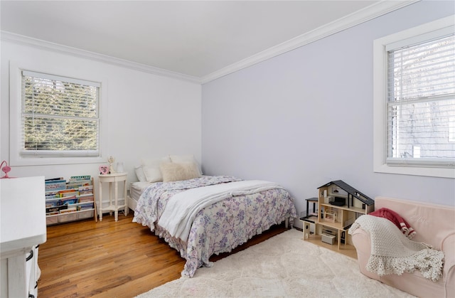 bedroom with crown molding and wood finished floors