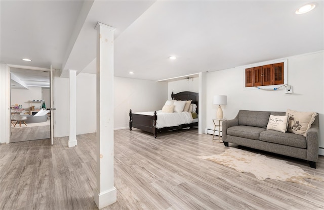 bedroom featuring a baseboard heating unit, wood finished floors, and recessed lighting