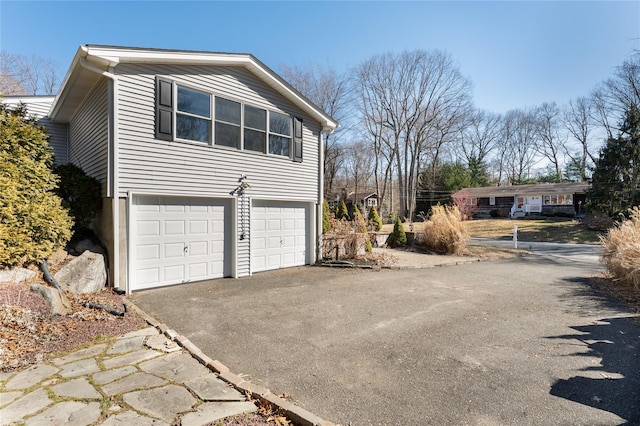 view of side of property with a garage and driveway