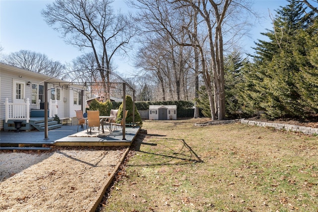 view of yard with an outbuilding, a storage shed, and a wooden deck