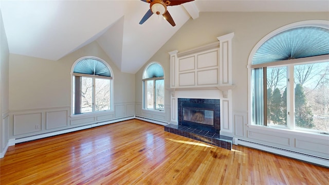 unfurnished living room featuring a tile fireplace, a baseboard radiator, wood finished floors, and a decorative wall