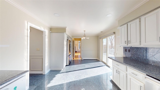 kitchen with ornamental molding, granite finish floor, baseboards, and stainless steel refrigerator