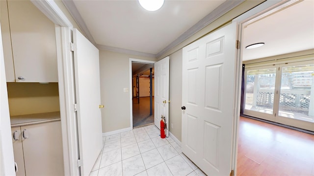 hall with ornamental molding and baseboards