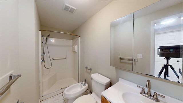 bathroom with a stall shower, visible vents, toilet, vanity, and a bidet