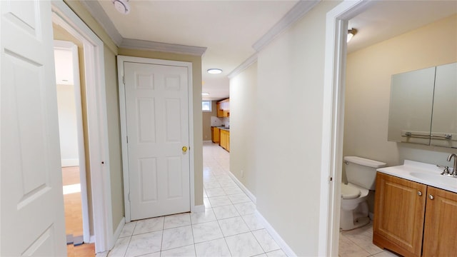 bathroom with tile patterned flooring, toilet, vanity, baseboards, and ornamental molding