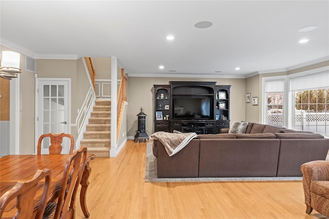 living area featuring light wood-style floors, recessed lighting, ornamental molding, and stairs