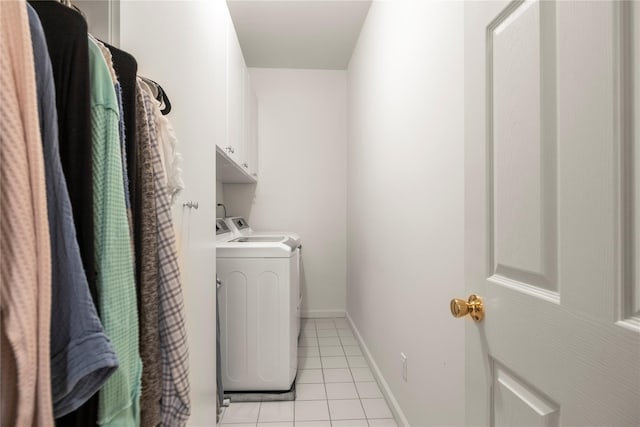 washroom with light tile patterned floors, washing machine and dryer, baseboards, and cabinet space