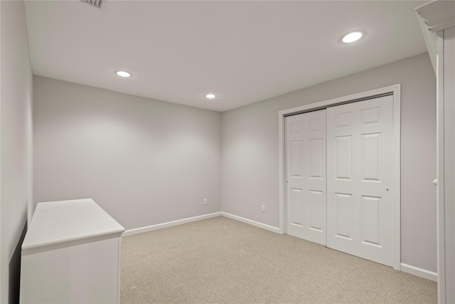 unfurnished bedroom with light carpet, baseboards, a closet, and recessed lighting