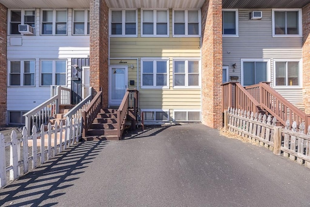 property entrance with cooling unit and fence