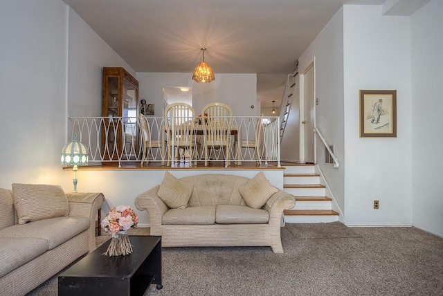 living room featuring a chandelier, carpet, and stairs