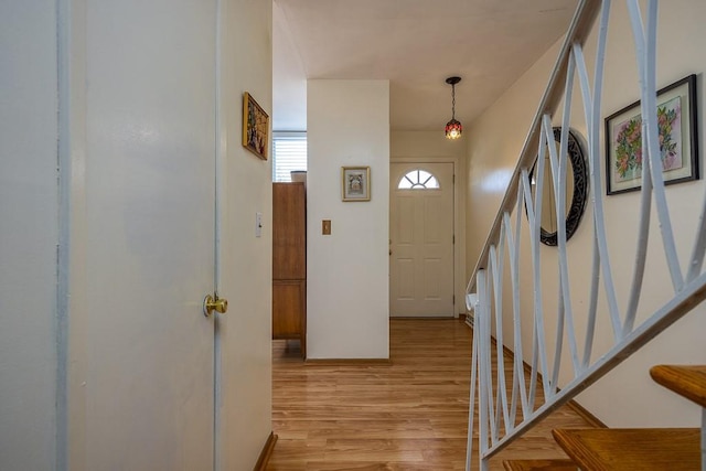 foyer entrance with stairway and light wood-style flooring