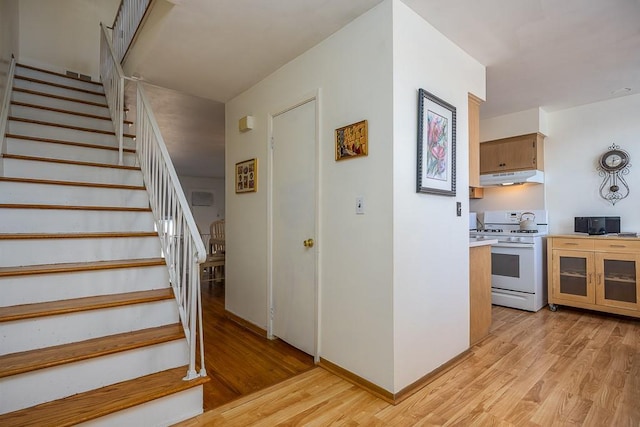 staircase featuring baseboards and wood finished floors