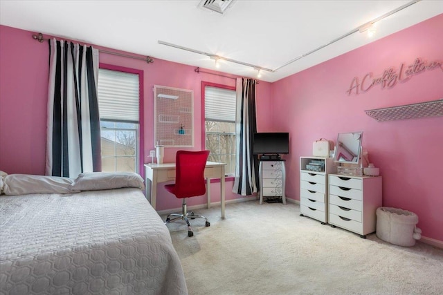 carpeted bedroom featuring visible vents, baseboards, and track lighting